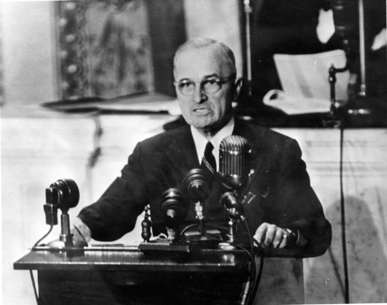 President Harry Truman addressing Congress at a podium of microphones