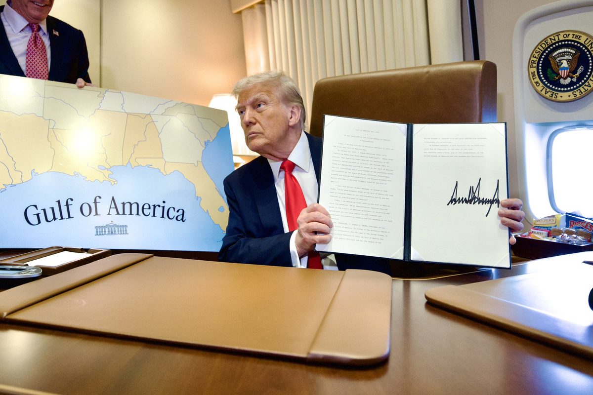 President Trump displays a signed proclamation aboard Air Force One beside a “Gulf of America” map